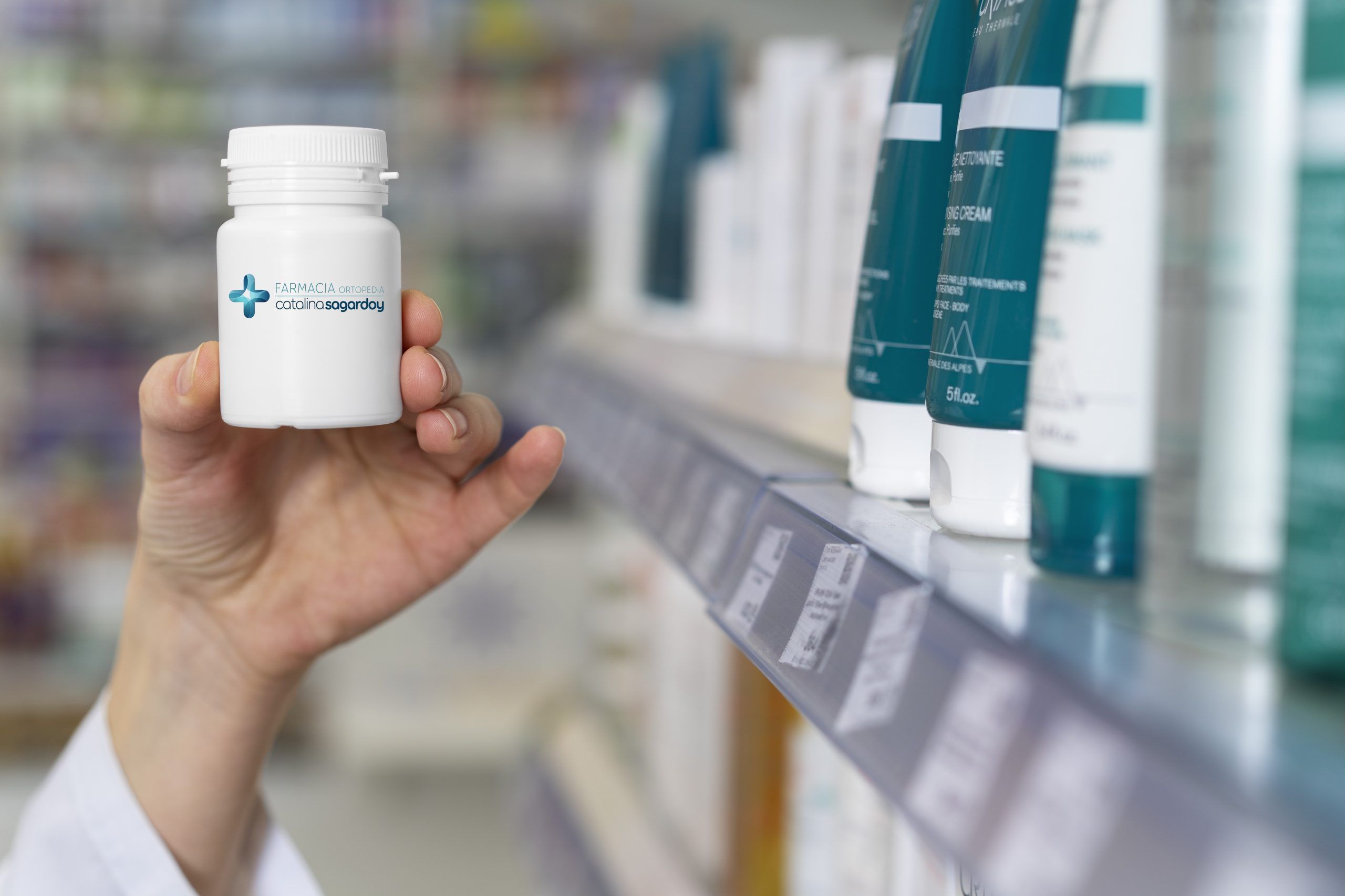 mano mostrando un bote blanco de cápsulas con la marca Farmacia Catalina Sagardoy